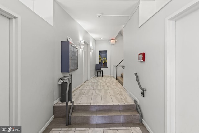 stairway with a mail area and tile patterned floors