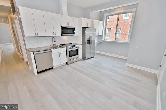 kitchen featuring stainless steel appliances, white cabinetry, and sink