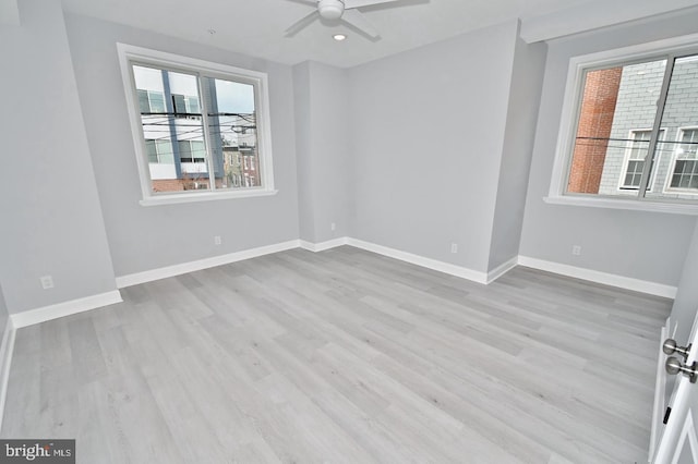 spare room featuring light hardwood / wood-style floors, plenty of natural light, and ceiling fan