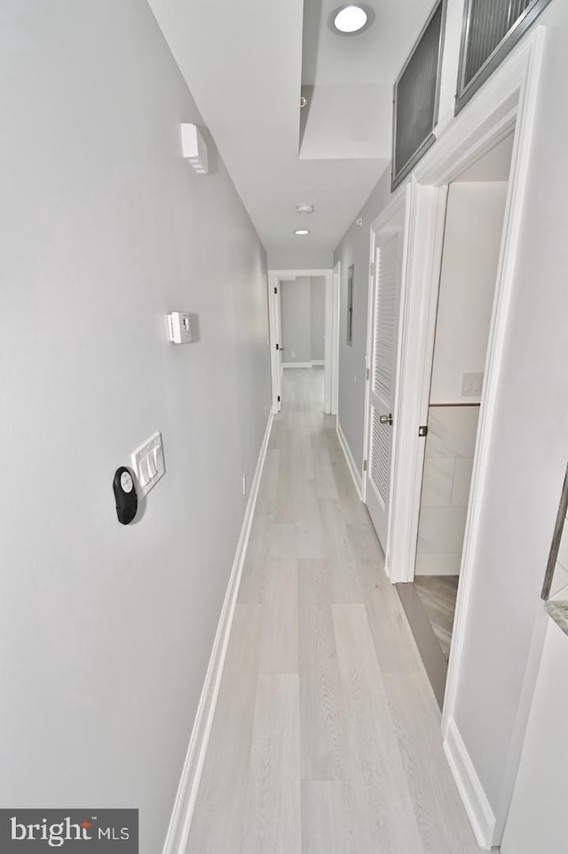 corridor with light hardwood / wood-style floors