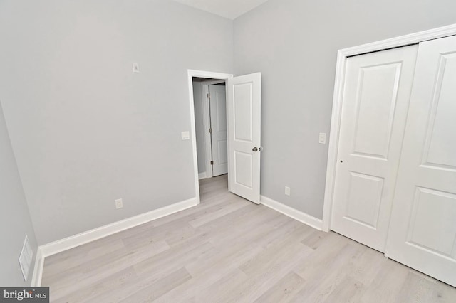 unfurnished bedroom featuring light wood-type flooring and a closet