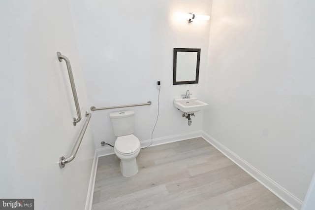 bathroom featuring sink, wood-type flooring, and toilet