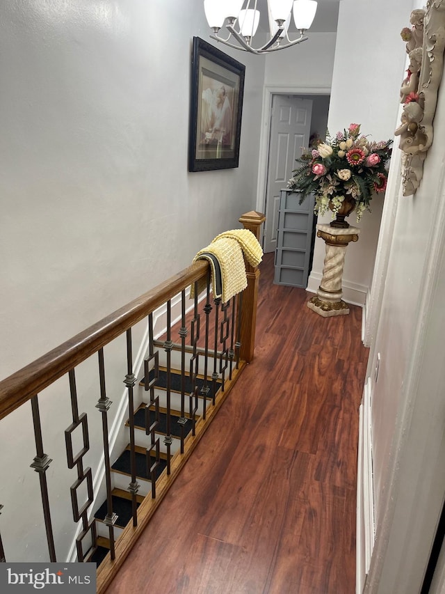 stairs with a notable chandelier and hardwood / wood-style floors