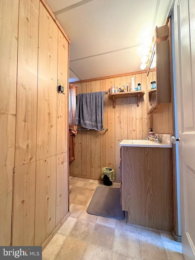 bathroom featuring vanity and wood walls