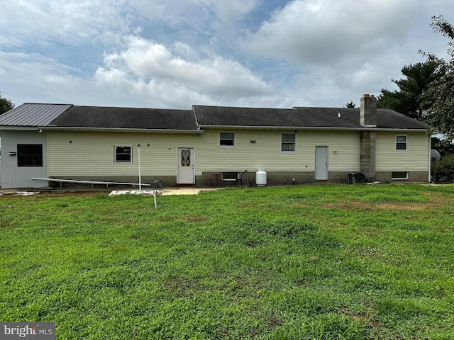 rear view of house featuring a lawn