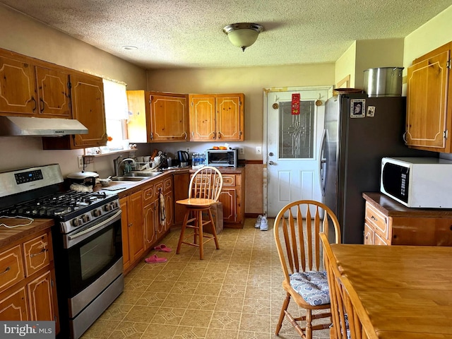 kitchen featuring a textured ceiling, appliances with stainless steel finishes, and sink