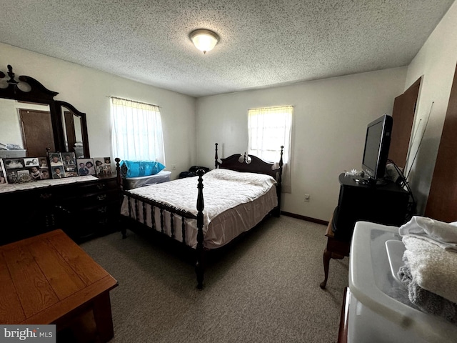 carpeted bedroom featuring a textured ceiling and multiple windows