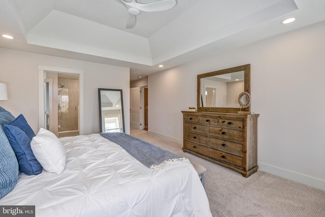 carpeted bedroom featuring ceiling fan, connected bathroom, and a raised ceiling