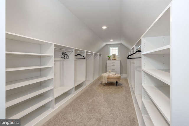 spacious closet featuring lofted ceiling and light colored carpet