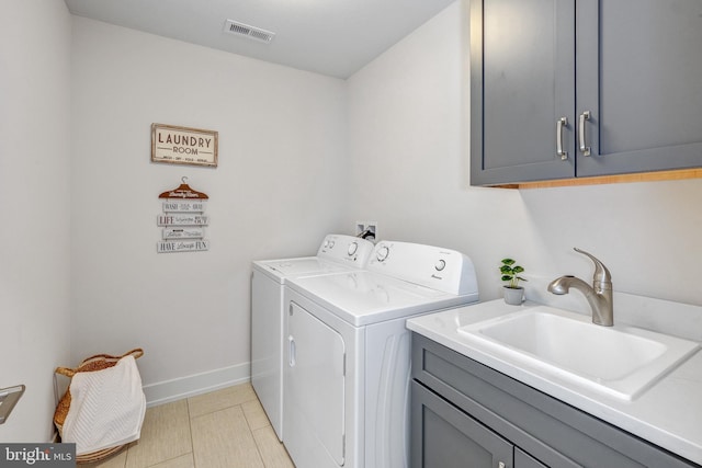 washroom with cabinets, sink, light tile patterned flooring, and washing machine and dryer