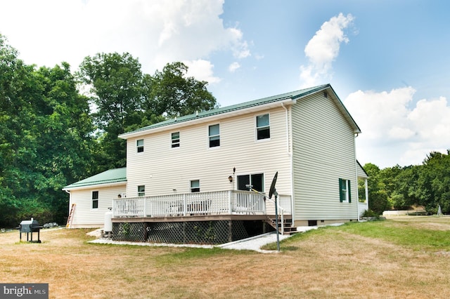 rear view of house with a lawn and a wooden deck