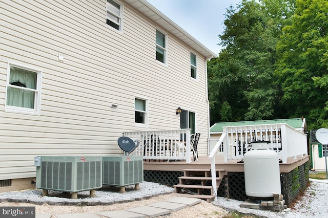 rear view of property featuring cooling unit and a deck