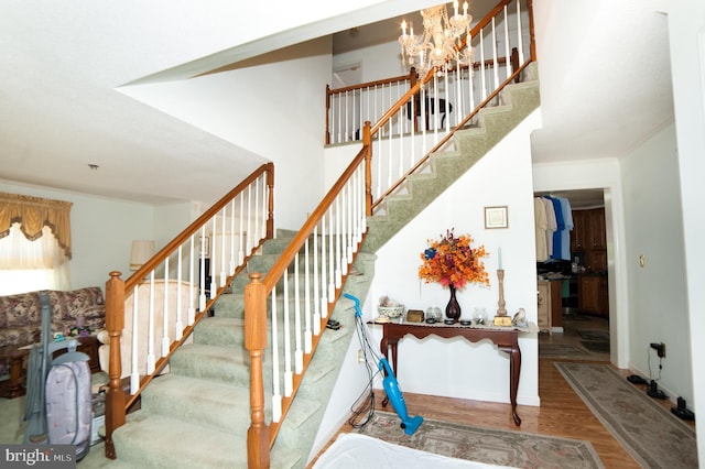 stairway featuring hardwood / wood-style flooring and a chandelier