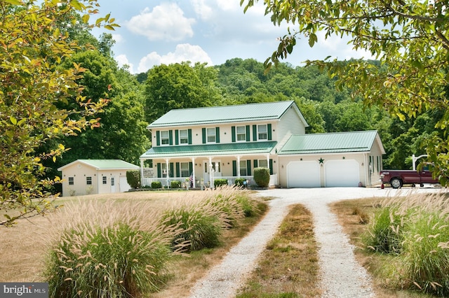 colonial home with a porch and a garage