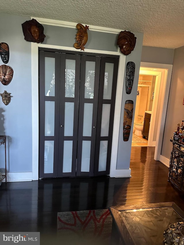 interior space featuring a textured ceiling, french doors, and wood-type flooring