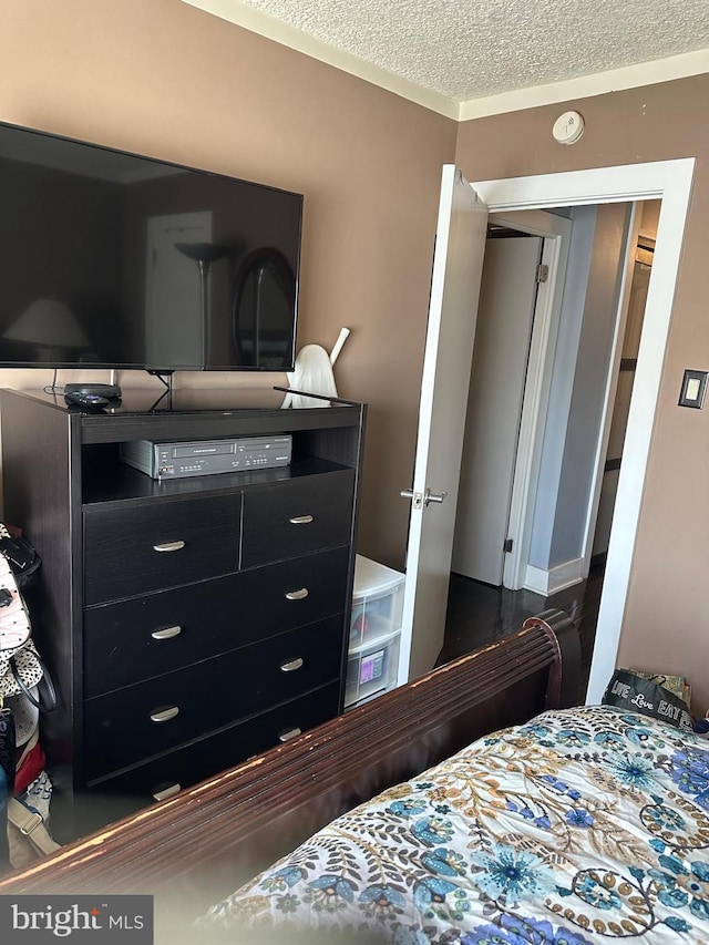 bedroom featuring crown molding and a textured ceiling