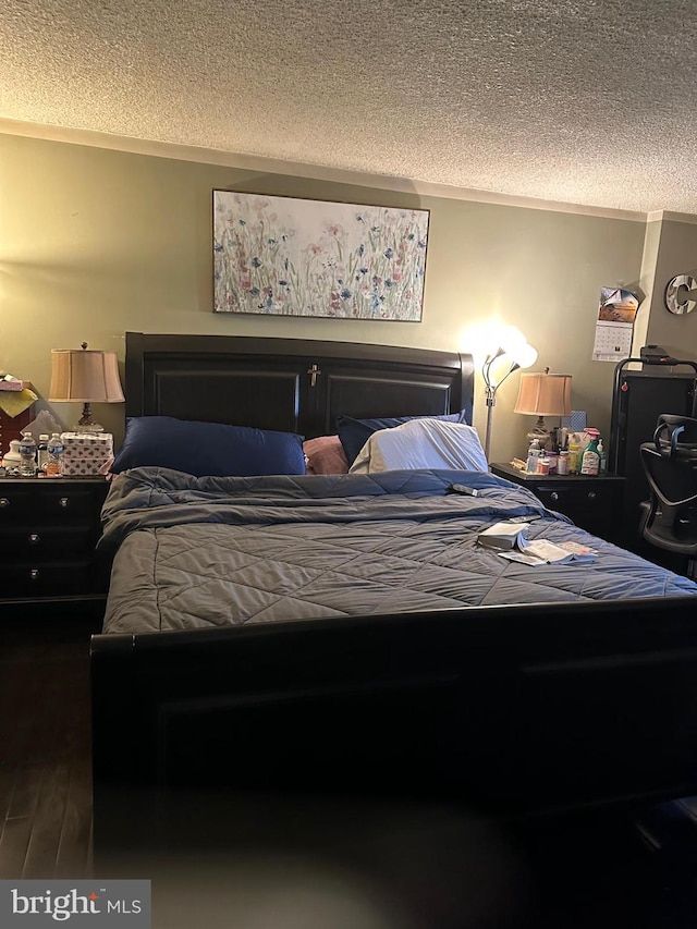 bedroom featuring dark hardwood / wood-style floors and a textured ceiling