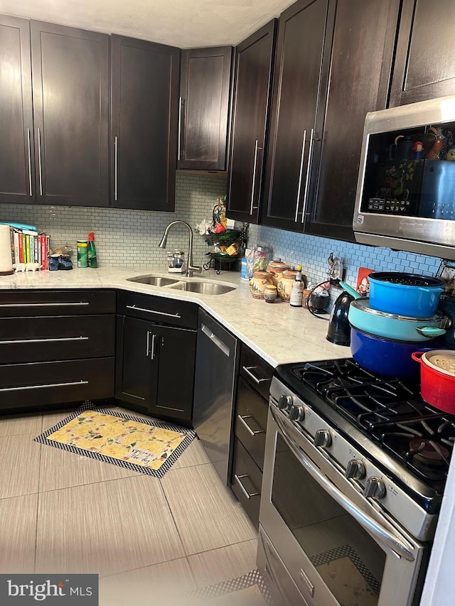 kitchen featuring stainless steel appliances, backsplash, dark brown cabinets, and sink