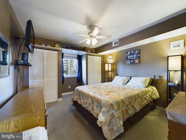 carpeted bedroom featuring visible vents, ceiling fan, baseboards, and multiple closets