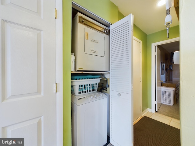 laundry room featuring stacked washer and clothes dryer, laundry area, and tile patterned flooring