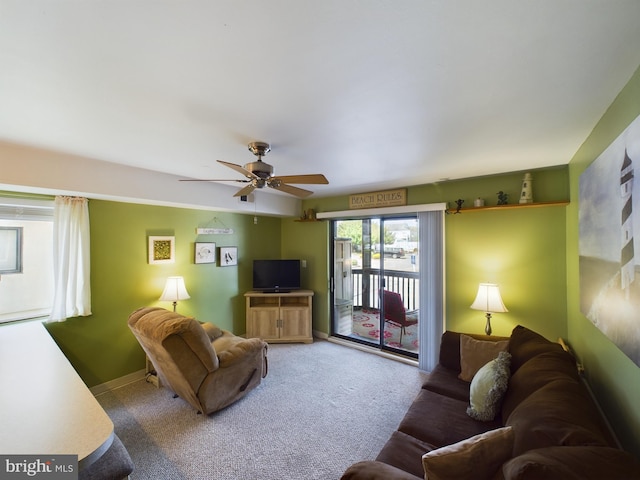 carpeted living area with a ceiling fan and baseboards