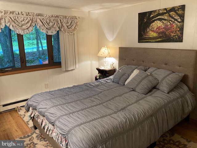 bedroom with hardwood / wood-style flooring and a baseboard radiator