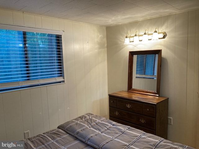 bedroom featuring wood walls