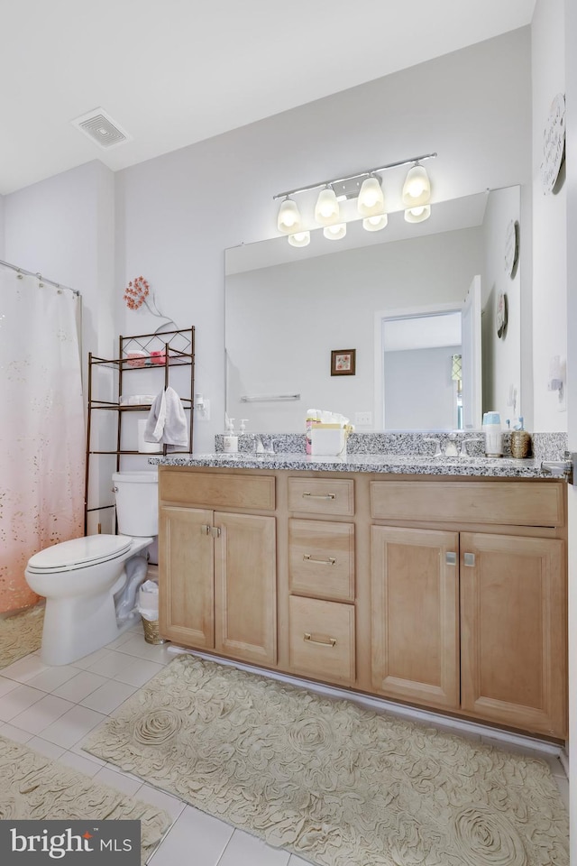 bathroom with vanity, toilet, and tile patterned floors