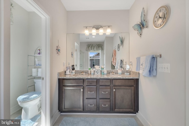 bathroom featuring double vanity and toilet