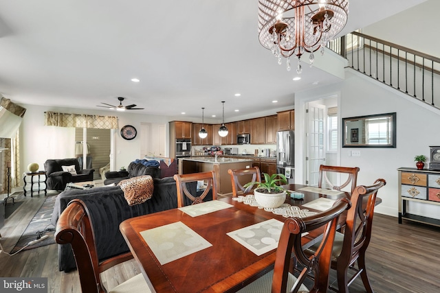 dining room featuring dark hardwood / wood-style flooring and ceiling fan with notable chandelier