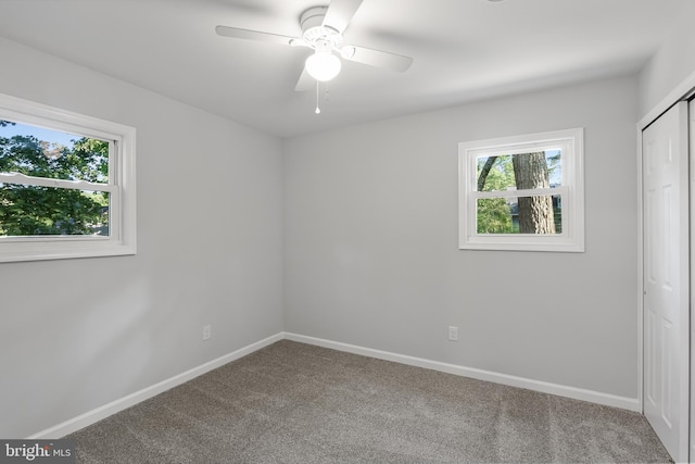 carpeted empty room featuring ceiling fan