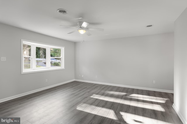 unfurnished room with ceiling fan and dark wood-type flooring