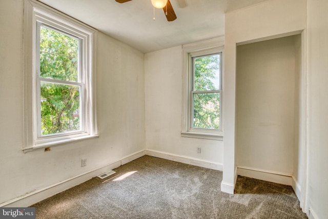 spare room featuring carpet floors, plenty of natural light, and ceiling fan