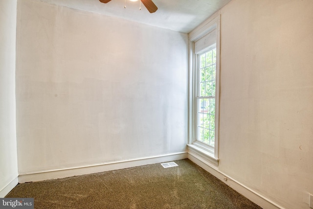 empty room featuring ceiling fan and a wealth of natural light