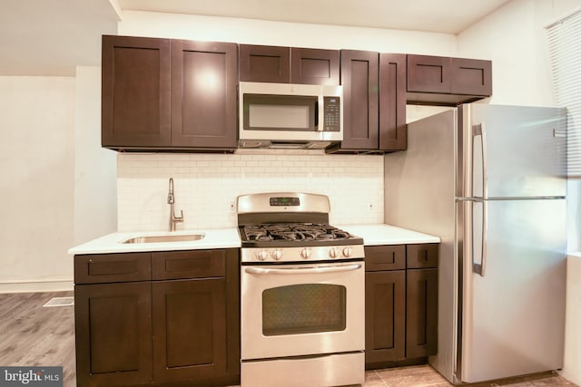 kitchen with decorative backsplash, sink, stainless steel appliances, and dark brown cabinets