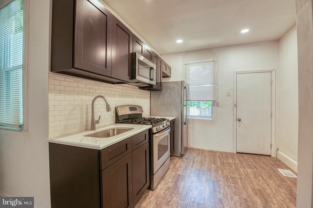 kitchen featuring decorative backsplash, sink, dark brown cabinets, and appliances with stainless steel finishes