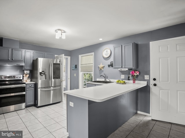 kitchen featuring stainless steel appliances, kitchen peninsula, and gray cabinets