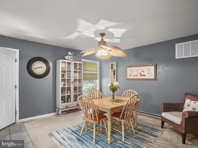 tiled dining area with ceiling fan and a baseboard radiator