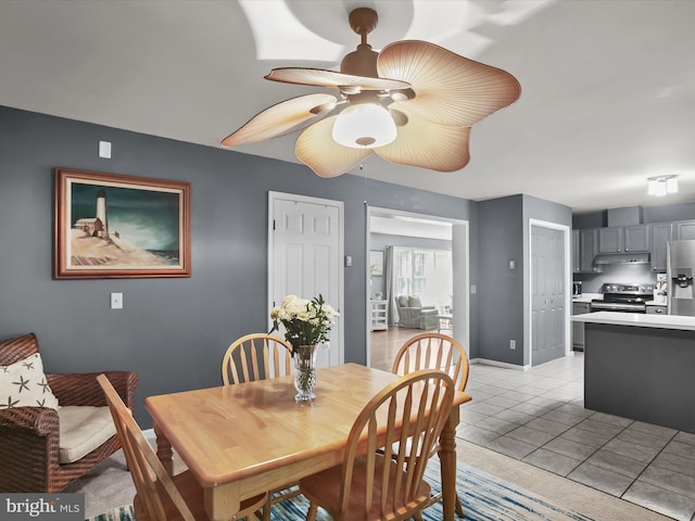 tiled dining space featuring ceiling fan