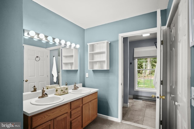 bathroom featuring a baseboard heating unit, vanity, and tile patterned flooring