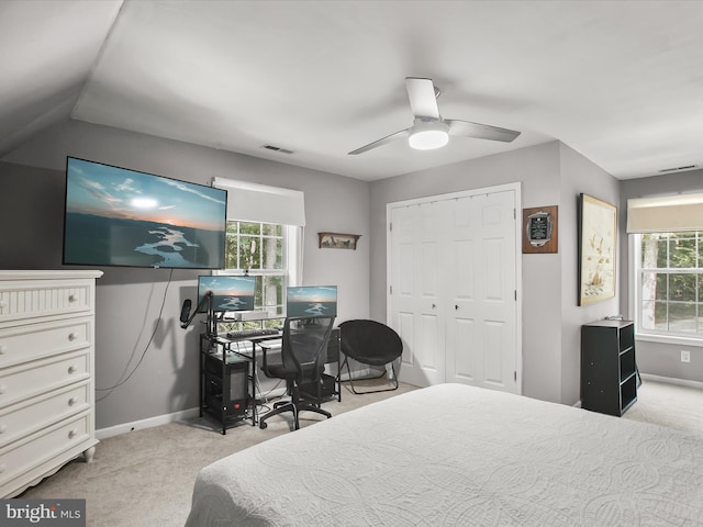 carpeted bedroom featuring ceiling fan, multiple windows, a closet, and lofted ceiling