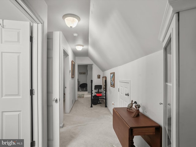 hallway featuring light colored carpet and vaulted ceiling