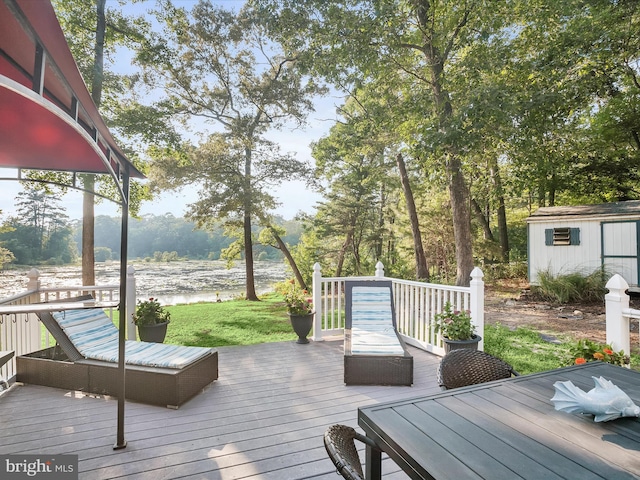 deck with a water view and a storage unit