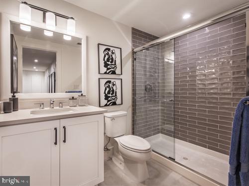 bathroom with vanity, toilet, and a shower with door