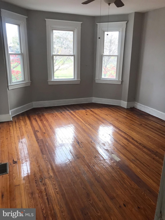 spare room with plenty of natural light, hardwood / wood-style floors, and ceiling fan