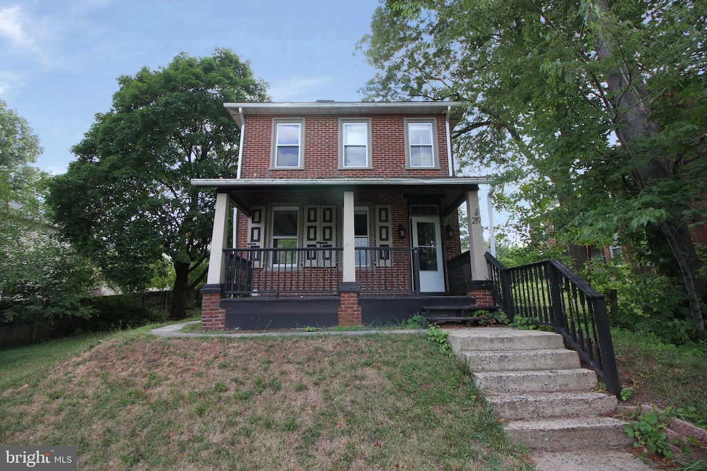 view of front of property featuring a front lawn and covered porch