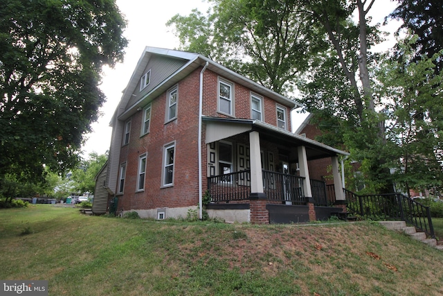 view of front of home featuring covered porch and a front yard