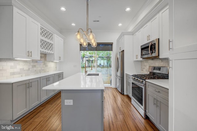 kitchen with pendant lighting, backsplash, sink, ornamental molding, and appliances with stainless steel finishes