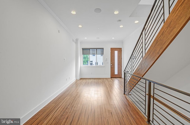 foyer entrance with light wood-type flooring and crown molding