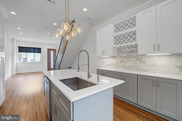 kitchen featuring gray cabinetry, decorative light fixtures, sink, and tasteful backsplash